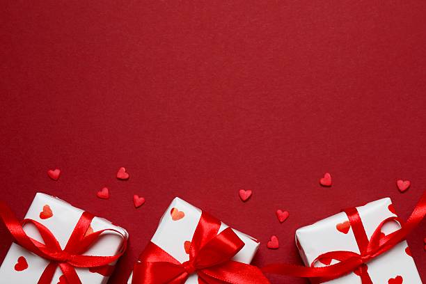 istock Gift boxes with red hearts on color background 2253117580