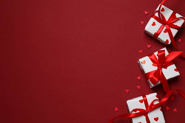 istock Gift boxes with red hearts on color background 2253117586