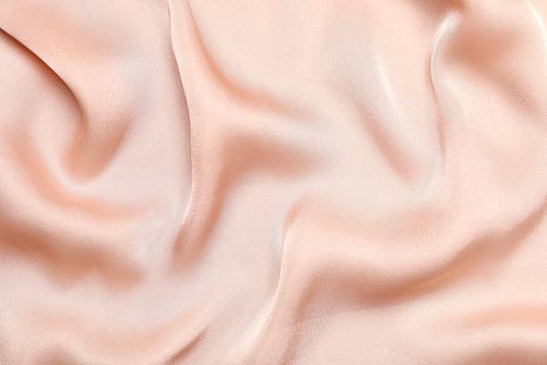istock Beige silk satin. Shiny smooth fabric. Soft folds. Luxury background with space for design. Flat table, top view 2253117618