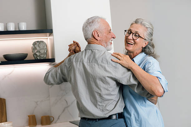 istock Senior couple dances happily at home during weekend together 2253117665
