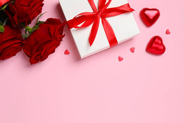 istock Beautiful red roses, gift box and hearts on pink background 2253117939