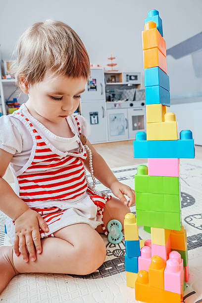 istock Toddler Playing with Colorful Building Blocks 2253119097