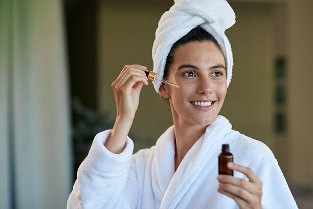 istock Woman applying oil serum on face 2253121257