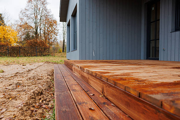 istock New cedar deck beside modern gray house with wet planks in late fall 2253123502