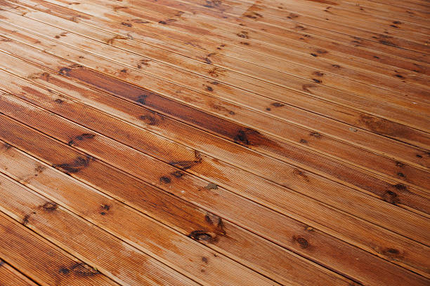 istock Wet timber deck close up with grooved planks, grain and knots in rain 2253123516