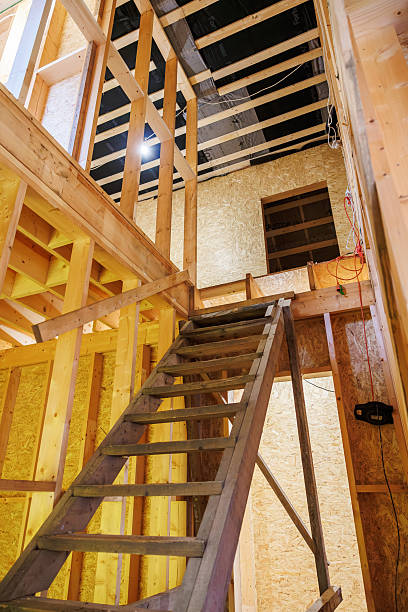istock Unfinished timber frame interior with steep temporary staircase 2253125041