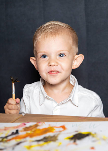 Painter. Boy with a brush in his hand. Painting. Art