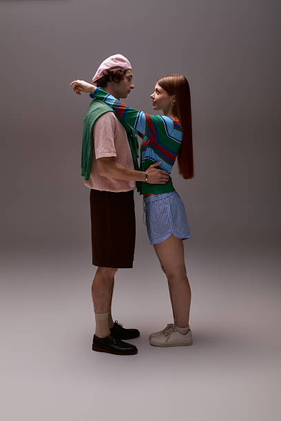 istock Stylish young couple embraces in fashionable outfits within a modern studio setting 2253128023