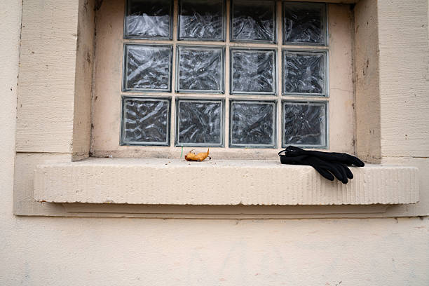 Senior woman standing by a window with a cane