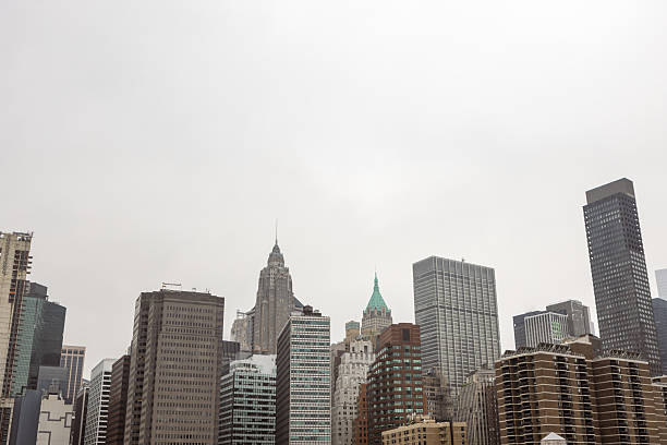 A cityscape view of urban skyscrapers under a cloudy sky. High-rise buildings of various architectural styles dominate the scene.