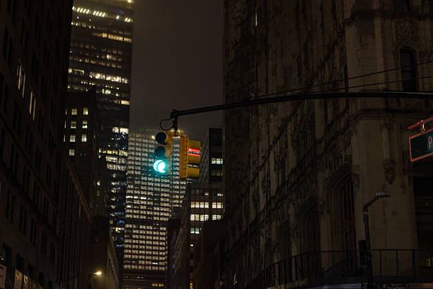 Skyscrapers of the financial district of Manhattan, New York City: a traffic light with a dramatic sunset light