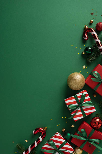 istock Festive vertical scene features wrapped gift boxes, candy cane, ornaments, and gold accents arranged along a green backdrop, perfect for Christmas, New Year, celebration, gift guide 2253131261