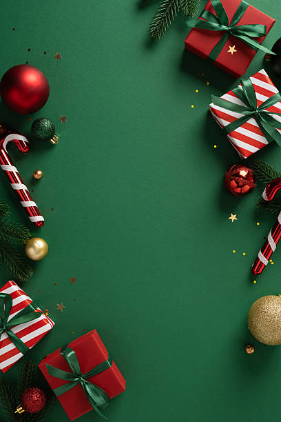 istock Vibrant vertical festive scene featuring wrapped gifts, candy canes and ornaments arranged along a green backdrop, capturing holiday spirit and New Year greetings 2253131264