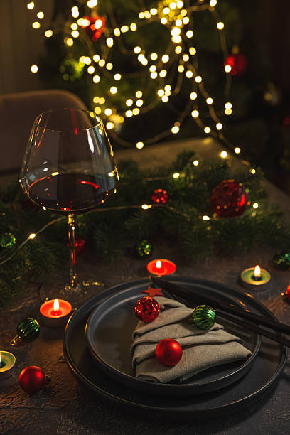 istock Christmas Table Setting with Tree-Shaped Napkin and Tealight Candles against Christmas lights 2253131938