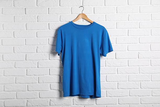 Hanger with blue t-shirt against white brick wall. Mockup for design
