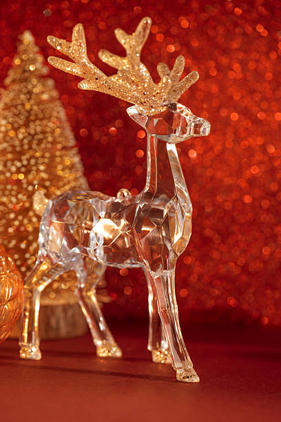 istock Crystal Reindeer with Golden Ornaments on Red Glitter Background 2253132065