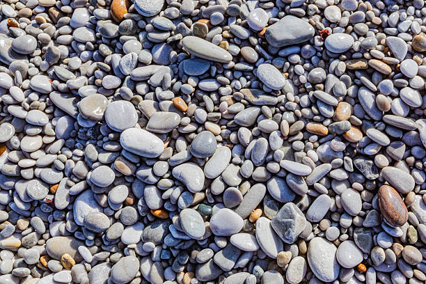 istock Close up view of small wet pebbles on a beach 2253133257