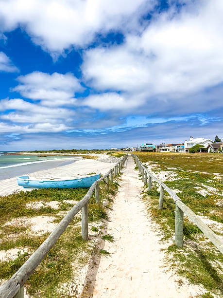 Small rowboat dinghy on a beach beneath beautiful blue azure sky