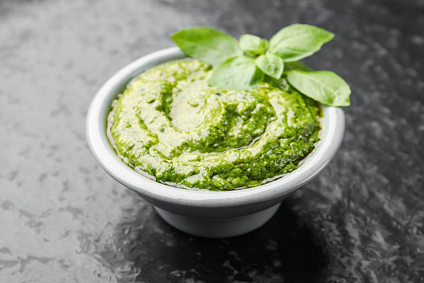 istock Fresh pesto sauce with basil leaves in bowl on black table, closeup 2253133473