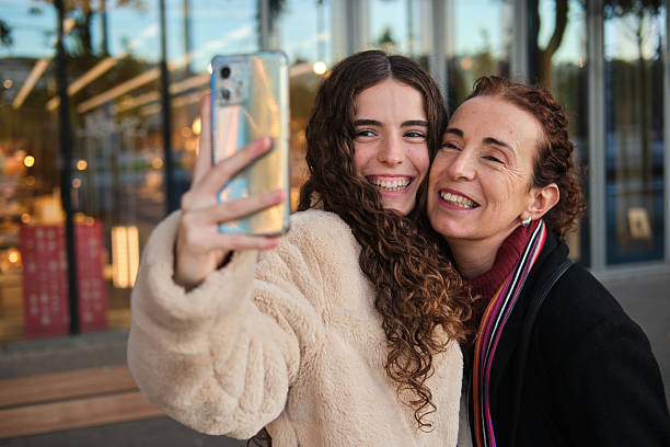 istock Mother daughter smiling making selfie with smartphone 2253133619