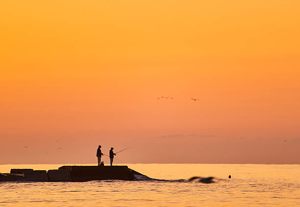 istock Fisherman on sunrise on the pier 2253134496