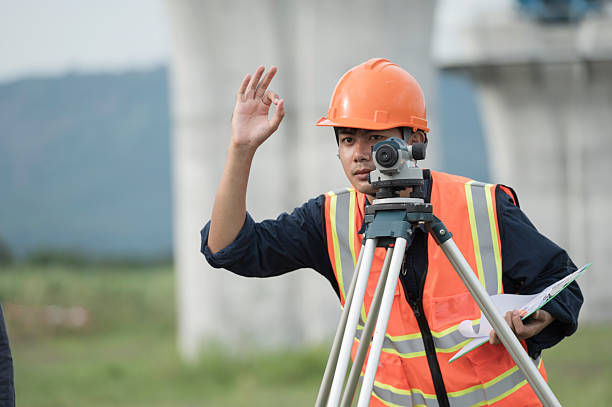 Silhouette of a surveyor working with total station.