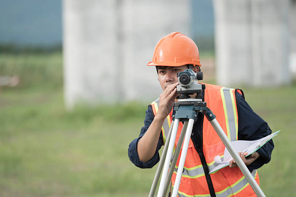 survey team is operating a leveling instrument during the construction of an elevated high-speed railway. The scene emphasizes precision engineering, modern infrastructure development, and the progress of advanced transportation systems.