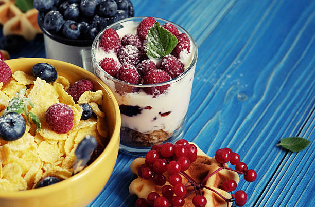 Healthy breakfast. Corn flakes with raspberries and blueberries, granola with yogurt and berries, wafers and milk. A great start to the day. Top view. Close up.