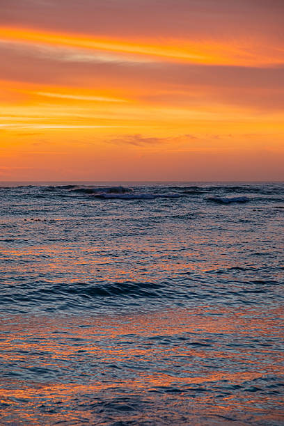 istock Dramatic Golden sunset over tranquil beach, waves lashing the pebble coastline 2253135992