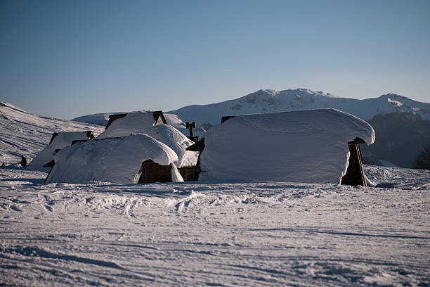 istock Winter landscape with snow-covered mountain huts 2253138292