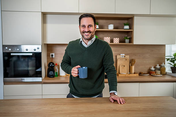 istock Happy man enjoying morning coffee in modern kitchen 2253139688