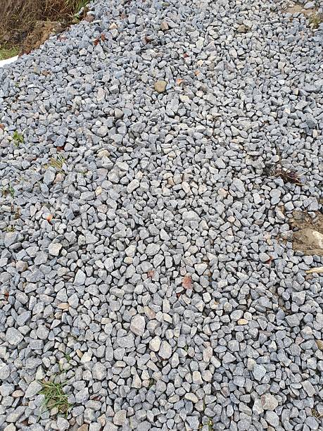 istock Uniform surface of coarse crushed stone. Textured stone background 2253140517