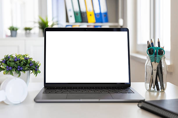 Laptop with blank white screen on modern office desk, ideal for mockup, presentation, website, app design and copy space concepts.