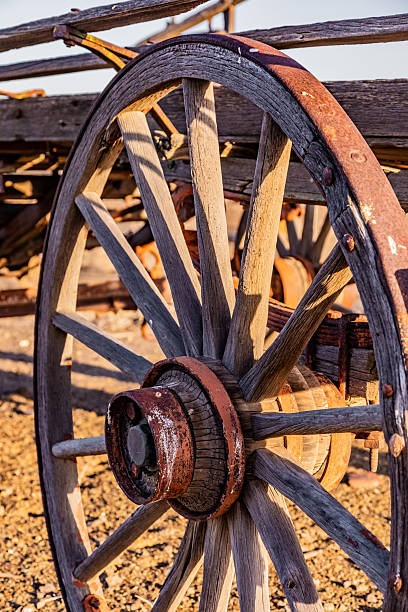 An old vintage wagon wheel against a rock building