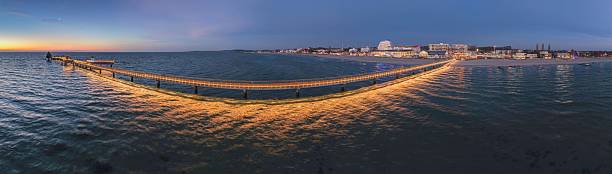Drone picture along the Groemitz pier leading into the Baltic Sea under colorful dusk sky