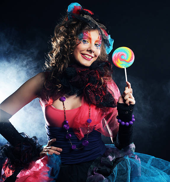 istock Girl with with creative make-up holds lollipop. 2253148425
