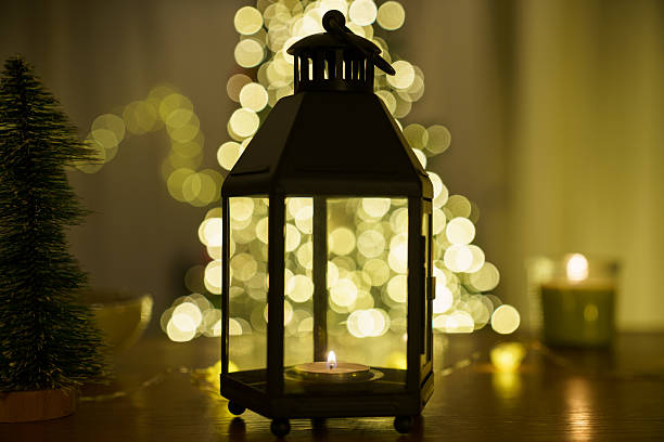 Cozy Christmas candle decoration with warm lights and miniature trees on wooden table. Festive holiday atmosphere, soft focus and bokeh lighting, winter home decor and celebration concept.