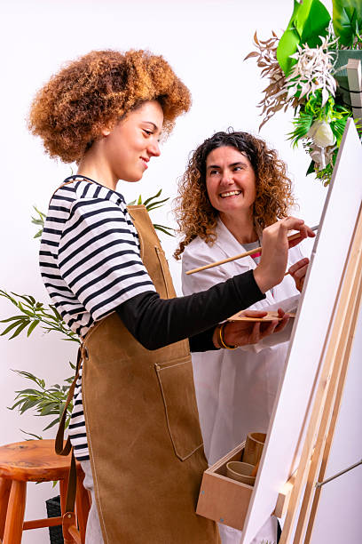 istock Young woman learning painting from art teacher 2253152241