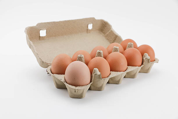 The organic eggs in egg tray on the wooden table and white background