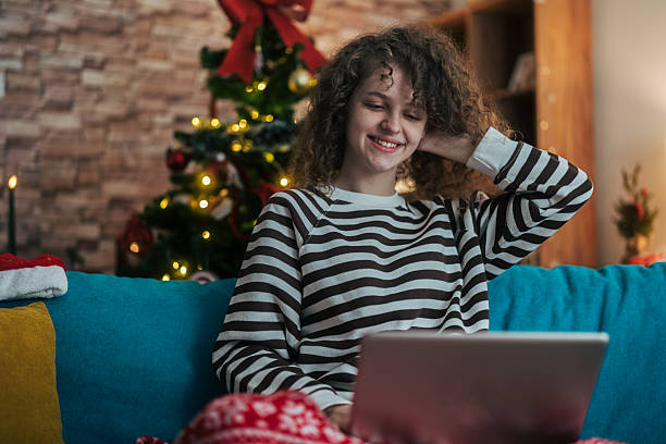 istock Young woman smiling using laptop during winter holidays 2253156689
