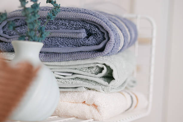 istock Neatly arranged towels on a bathroom shelf with a vase 2253157902