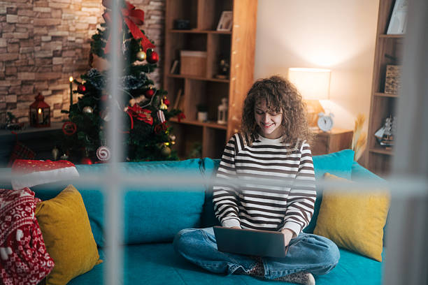 istock Young woman using laptop at home during christmas holidays 2253158471