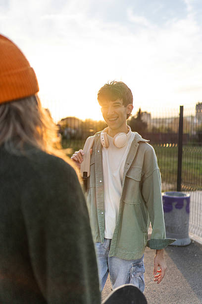 istock Two young men smiling talking at sunset in skatepark 2253166504