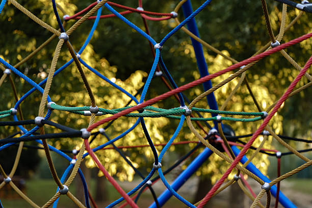 Close view of a rope climbing frame at a playground during a sunny afternoon.
