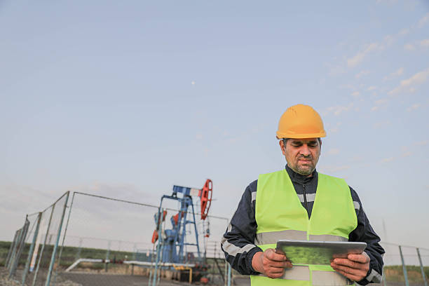 istock Engineer Reviewing Plans At Oil Field 2253169753