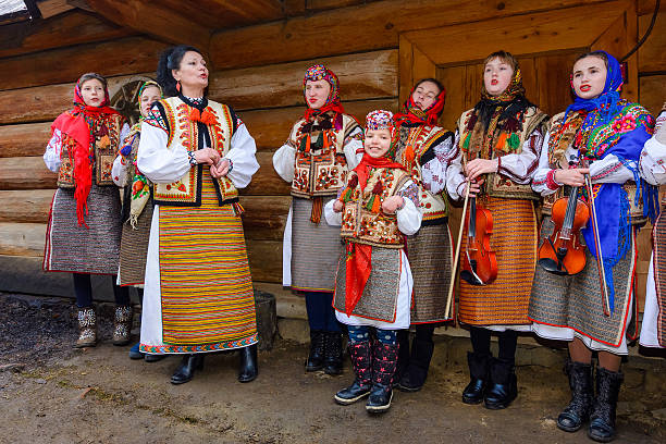 uzhhorod, ukraine - 13 jan, 2018: hutsuls singing christmas carols outdoor. folk music festival during winter holiday of ts. basil. group of children in traditional closes having fun