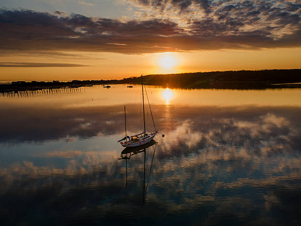 istock A Lone Sailboat With Cloudy Sunrise Reflections 2253170413