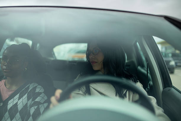 istock Two female friends sitting in car seen through windshield 2253171766