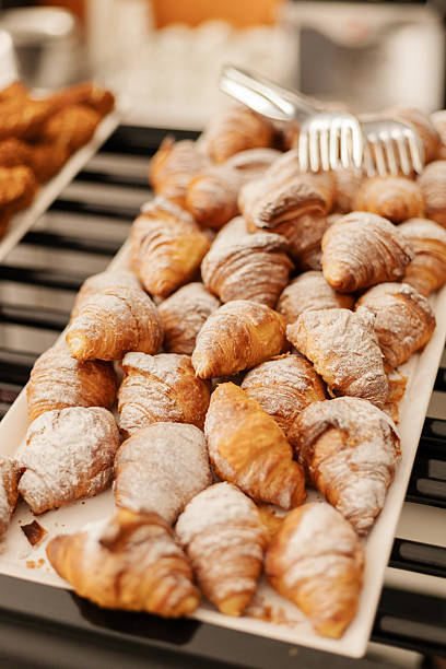 istock Croissants sit on a white tray at a local bakery. Some have powdered sugar on top. Customers can see a variety of pastries available for breakfast 2253171945