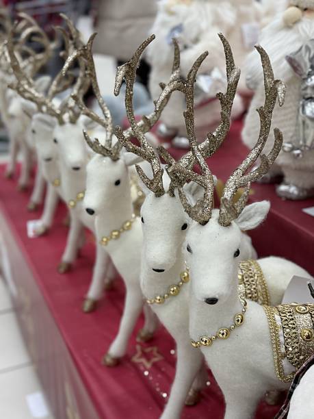 istock Decorative White Reindeer On Table, Seasonal Gift Display Featuring Handcrafted Reindeer Ornaments, Closeup Of Artistic Reindeer Figures With Beads And Gold Details On Market Stall 2253173039